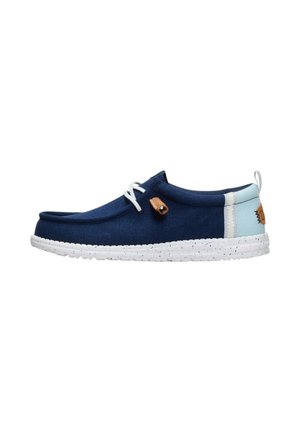 Zapato náutico azul marino con talón azul claro, suela moteada blanca, cordones blancos y detalle en cuero marrón claro en el lateral y en la lengüeta trasera.