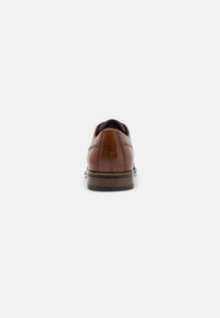 Scarpa da dress in pelle marrone con finitura liscia, forma arrotondata e suola piatta. Presenta cuciture sottili lungo la parte superiore.