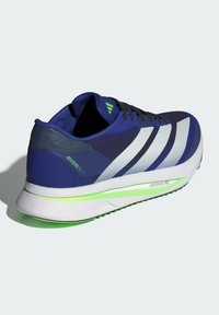 Blue athletic shoe with a mesh upper, featuring white striped accents, a green logo, and a white sole with green detailing.