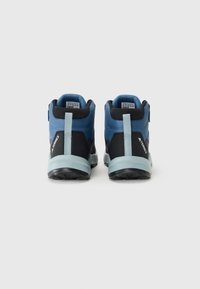 Blue and black hiking shoes with a high ankle design, textured fabric upper, reinforced heel, and a flexible light blue sole.