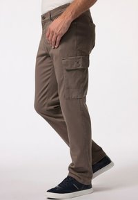 Hnědé kapsáče s rovný střihem, se bočními kapsami a zapínáním na knoflík. V páru s námořnickými teniskami s bílou podešví.