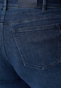 Ciemnoniebieskie dżinsy z denimu o teksturowanym wykończeniu. Posiadają tylną kieszeń oraz skórzaną metkę z logo "s.Oliver" na pasku talii.