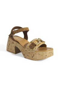 Braune Wildleder-Sandale mit Kork-Blockabsatz, strukturiertem Obermaterial, goldenen Hardware-Details und gepolstertem Fußbett.