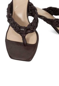Brown leather sandals with braided straps, square toe, and a smooth, nude insole. Textured detailing on the straps.