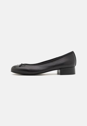 Schwarze Leder-Ballettschuhe mit kleinem rechteckigem Absatz, runder Spitze, dekorativem Schleifendetail und elastischem Besatz am Einstieg.