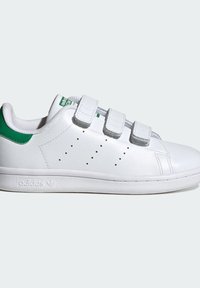 Baltas ādas sporta kurpes ar trim Velcro siksnām, zaļiem akcentiem uz papēža, perforētiem detaļām sānos un teksturētu gumijas zolīti.