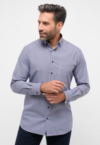 Camicia a quadri blu e bianca con colletto classico, maniche lunghe e polsini con bottone. Presenta una vestibilità regolare e un orlo dritto.