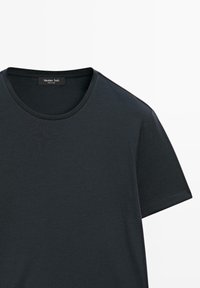 Sort bomulds T-shirt med rund hals. Korte ærmer og en glat tekstur. Mærket siger "Massimo Dutti." Simpelt design, ingen mønstre eller accenter.