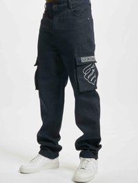 Tummansiniset cargo-housut, jotka on valmistettu denimmateriaaleista. mukana suuret sivutaskut, joissa on valkoinen "ROCAWEAR"-logo, sekä rento istuvuus. Yhdistetty valkoisiin tennareihin.