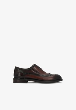 Scarpa Oxford da uomo in pelle marrone con dettagli neri, punta traforata e tacco basso a blocco, vista laterale su sfondo bianco.