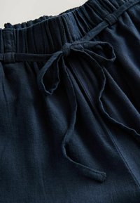 Sötétkék, elasztikus derékpántos nadrág, húzószalaggal, puha, texturált anyagból készült, és redőzött dizájnnal a kényelem fokozása érdekében.