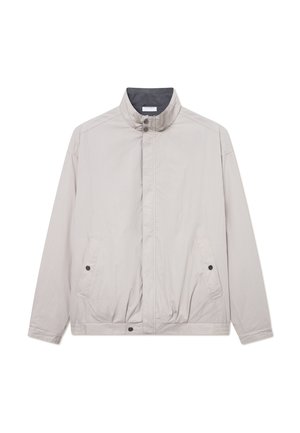 Svetlosivý vetrovka s vysokým golierom, predným zapínaním na patentky, dvoma bočnými vreckami a hladkým, mierne textúrovaným materiálom.