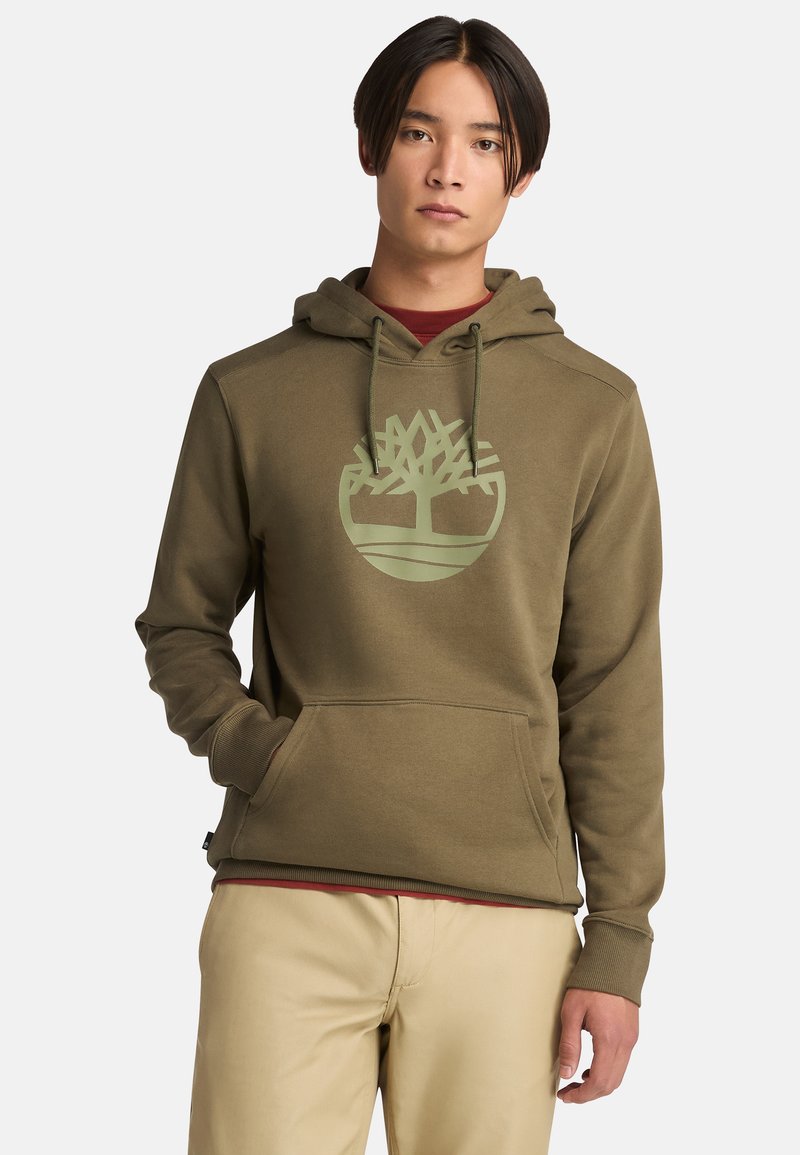 Sudadera verde oliva hecha de una tela suave, con un gran logo de árbol en verde claro y un bolsillo tipo canguro. La sudadera tiene puños ribeteados.