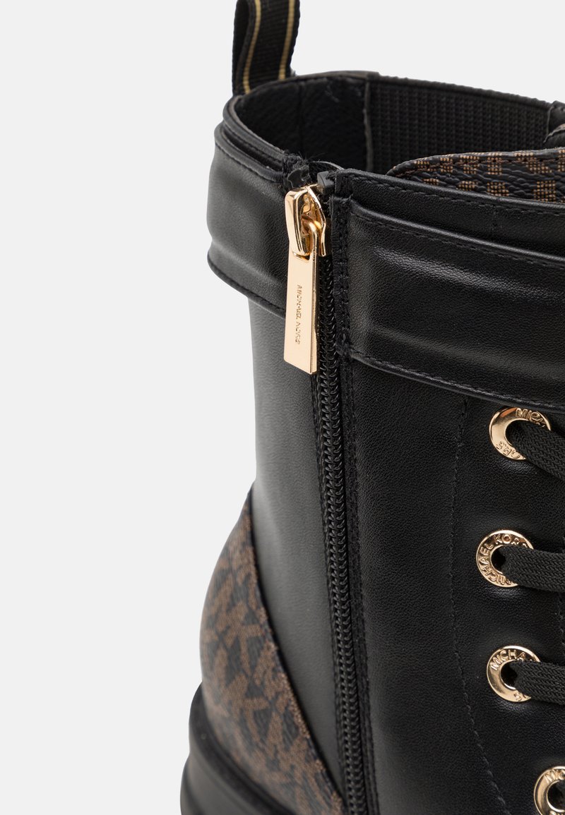 Czarna skórzana boot z złotymi elementami, z boku z zamkiem błyskawicznym oraz brązowym wzorzonym materiałem w dolnej części. Teksturowane wykończenie i sznurowadła.