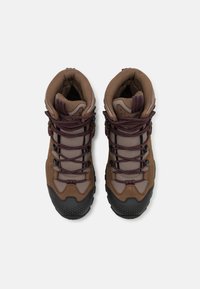 Bruine wandelschoenen met een getextureerde rubberen zool, bovenwerk van mesh en suede, verstevigde neuskap en bordeauxrode veters. Kenmerkt zich door een gewatteerde enkelsteun.