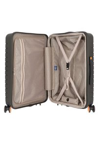 Valigia rigida di colore verde scuro con interno beige. Caratteristiche includono una tasca con zip, cinture regolabili e quattro ruote per la mobilità.