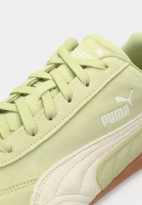Tenisi din suede verde deschis cu accente crem, șireturi plate și un panou lateral texturat. Prezintă un logo alb Puma pe partea exterioară.