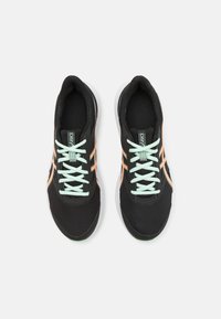 Des chaussures de sport noires avec une tige en mesh, des lacets de couleur menthe et des accents oranges. Elles présentent une semelle rembourrée et un design respirant.