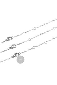 Collana in argento caratterizzata da anelli circolari e tre ganci a moschettone. Include un ciondolo rotondo inciso con la scritta "CHIC" e un accentuatura testurizzata attorno al bordo.