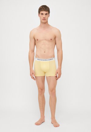 Sárga boxer nadrág elasztikus anyagból, fehér derékpánttal, rajta a 'POLO RALPH LAUREN' logóval. Egyszerű, testhezálló dizájn.