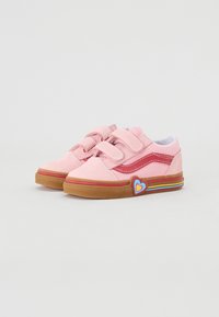 Chaussures en suede rose avec une bande latérale rouge, sangles ajustables, semelle en caoutchouc, et un accent en forme de cœur arc-en-ciel sur le côté extérieur.
