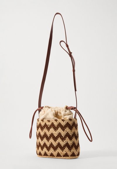 Μικρή πλεκτή τσάντα τύπου κουβά με καφέ και μπεζ ζιγκ-ζαγκ σχέδιο, μπεζ υφασμάτινο κορδόνι κλεισίματος και ρυθμιζόμενη καφέ δερμάτινη ανάρτηση.