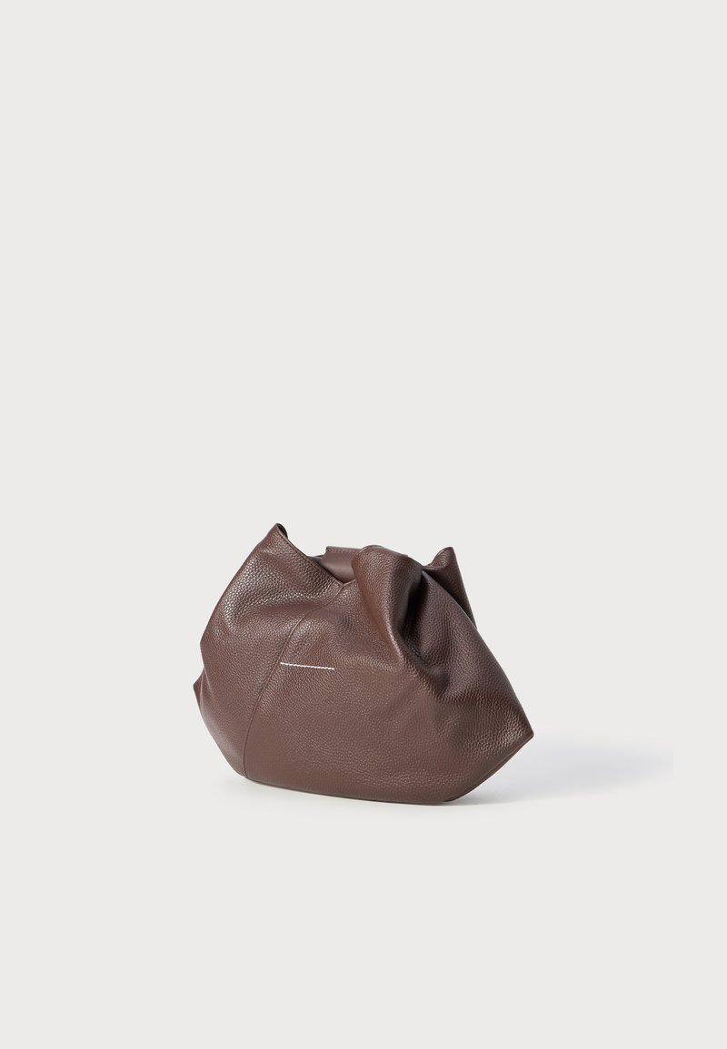 Weiche, braune Lederhandtasche mit einem lässigen, gerafften Design, vor einem schlichten, hellgrauen Hintergrund platziert.