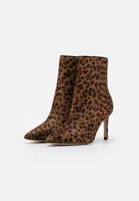 Botines con estampado de leopardo en tejido suave, con punta puntiaguda y tacón de aguja. Patrón de colores marrón y negro; diseño elegante y afilado.