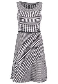 Robe sans manches noire et blanche à motifs combinés de pois géométriques et de rayures, avec une fine ceinture noire à la taille.