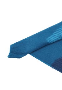 Sciarpa blu realizzata in tessuto morbido e testurizzato, caratterizzata da un motivo a gradiente con tonalità più chiare e bordi leggermente sfilacciati.
