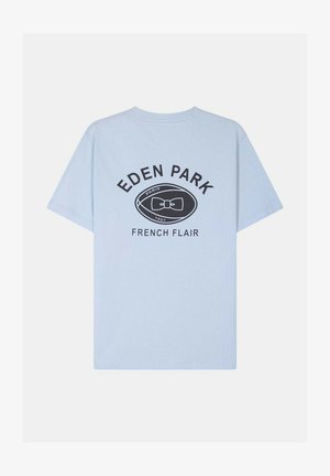 T-shirt bleu clair à manches courtes avec le texte "EDEN PARK", un logo ovale présentant un nœud papillon, et "FRENCH FLAIR" imprimé dans le dos.