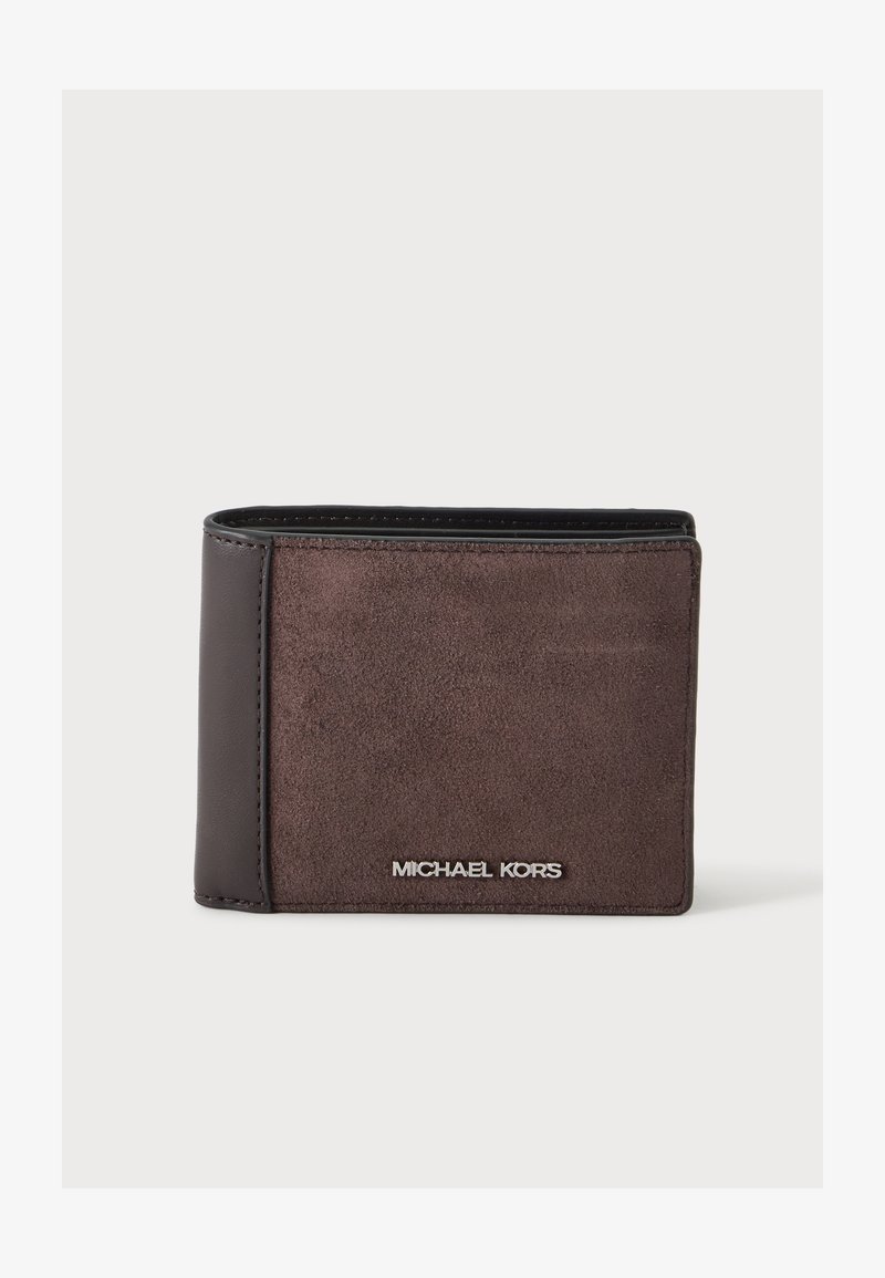 Καφέ πορτοφόλι Michael Kors δίπτυχης σχεδίασης από σουέτ και δέρμα με ασημένιο λογότυπο μπροστά σε λευκό φόντο.