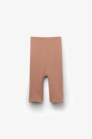 Lys brun knælang sømløs shorts lagt fladt på en hvid baggrund.