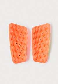Orange silikonesåler til sko med et honningkombinationsmønster og udskæringer for åndbarhed. Glat overflade, kontureret form og let design.