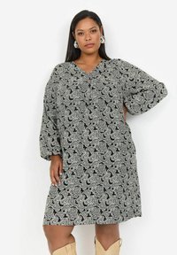Šaty s čierno-bielym paisley vzorom, oversized strih s výstrihom do V, 3/4 rukávy, voľný strih a mäkká textúra látky.