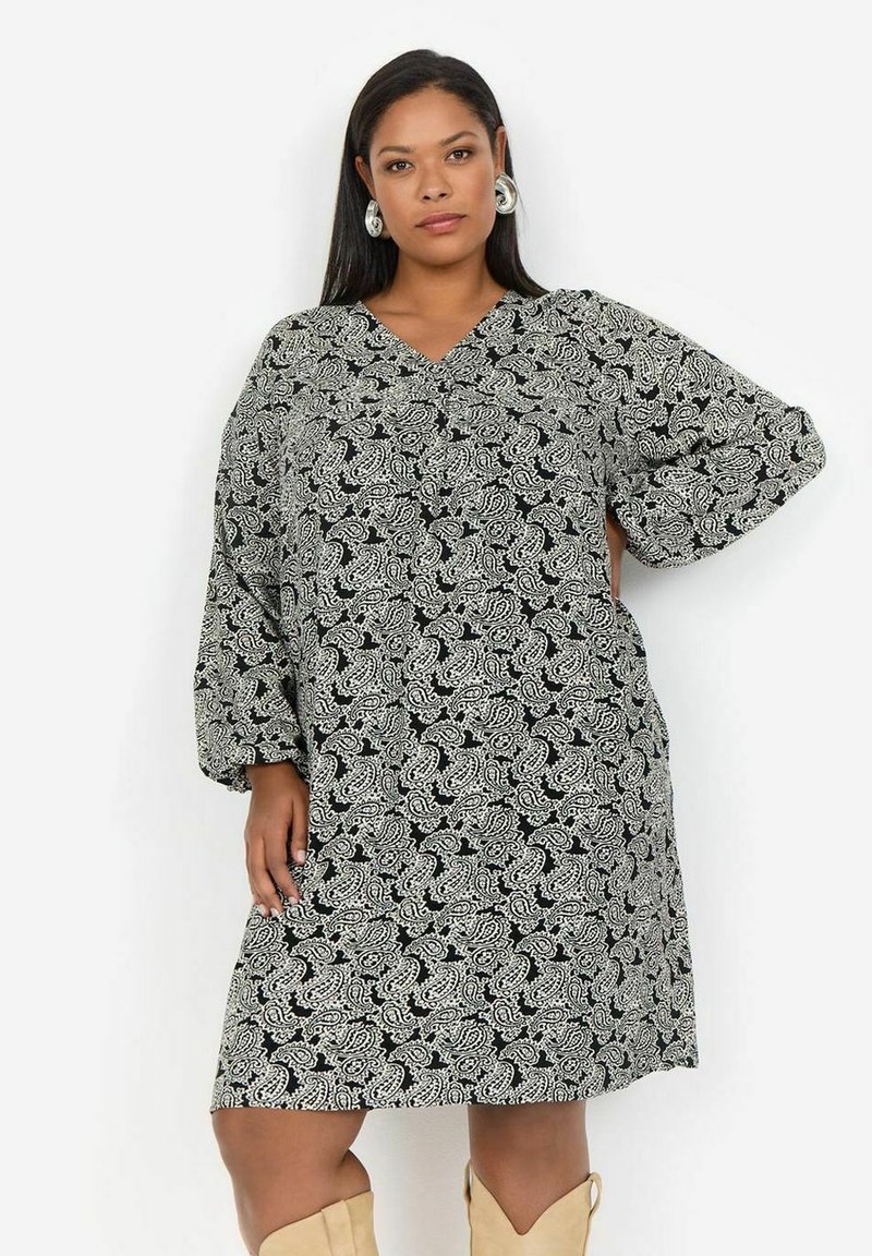 Šaty s čierno-bielym paisley vzorom, oversized strih s výstrihom do V, 3/4 rukávy, voľný strih a mäkká textúra látky.