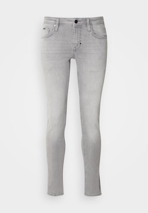 Jeans en denim gris avec une coupe slim, cinq poches et une fermeture éclair. Présente un léger délavage et des détails de couture le long des coutures.