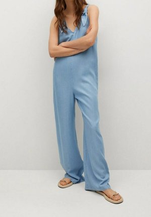 Jasnoniebieski kombinezon z miękkiego materiału. Posiada cienkie ramiączka, dekolt w serek oraz luźny krój. Ozdobiony kokardą na lewym ramieniu.