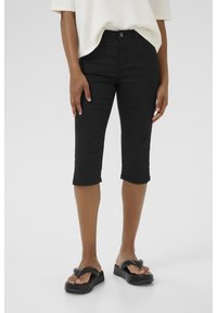 Black cropped jeans in stretch denim with a fitted design, featuring a five-pocket style and a mid-rise waist. Paired with black slide sandals.