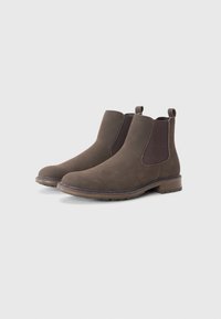 Botas Chelsea de ante marrón con paneles elásticos laterales, puntera redonda y tacón bajo cuadrado. Presentan una suela texturizada para mayor agarre.