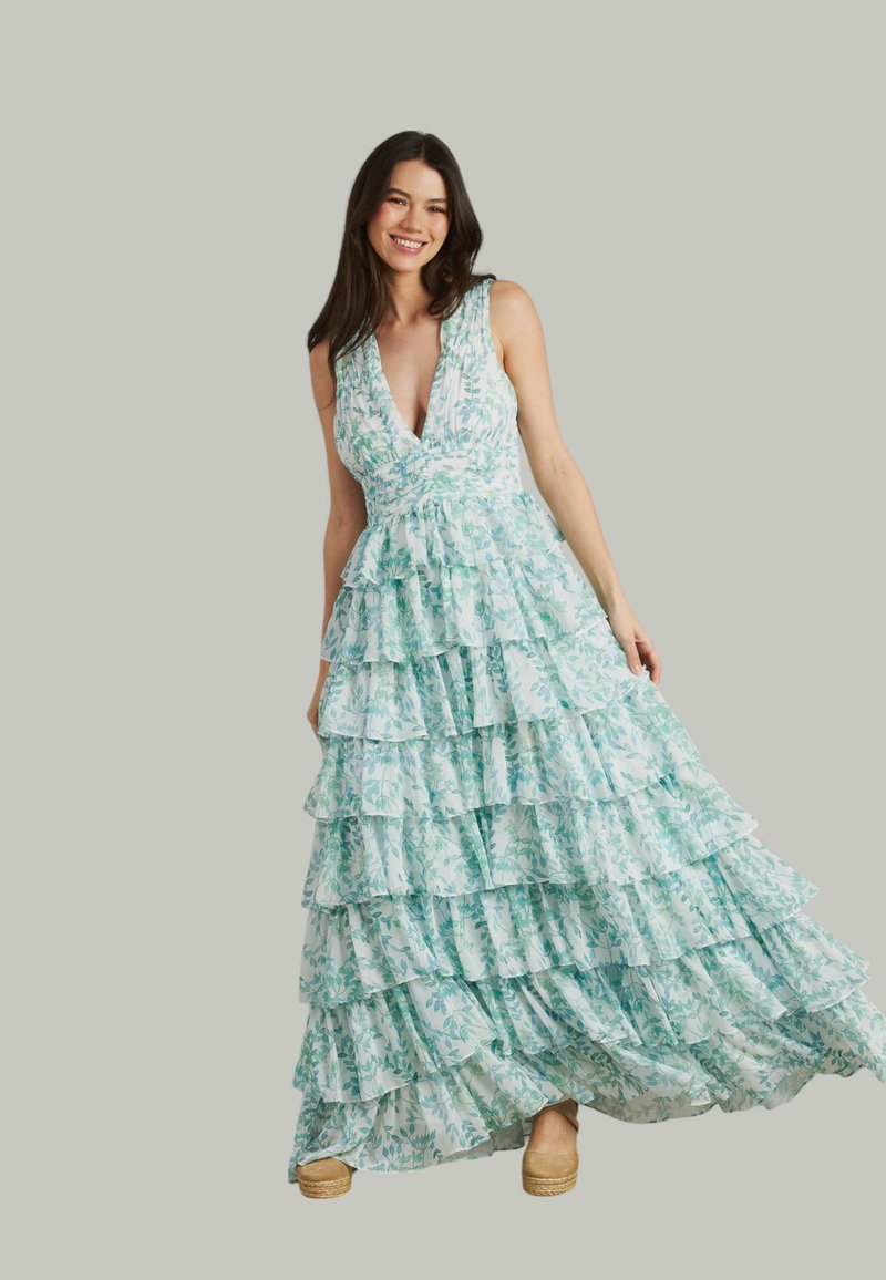 Larga vestido de capas en estampado floral de color azul claro y verde, con un profundo escote en V, diseño sin mangas y dobladillo con volantes. Textura grabada.