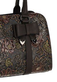 Sac à main marron embossé de motifs floraux avec un nœud et des accents métalliques. Cuir texturé avec des motifs floraux colorés et des poignées robustes.