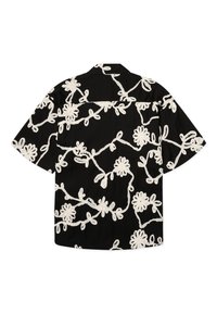 Chemise noire à manches courtes avec des motifs floraux abstraits blancs en forme de vignes couvrant le tissu, vue de dos.