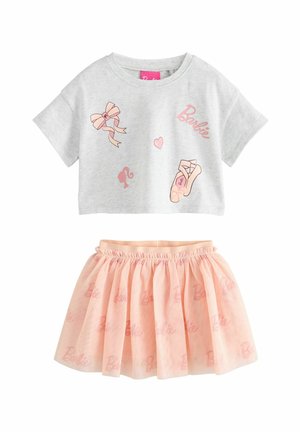 Tenue deux pièces pour filles avec un crop top gris clair orné d’imprimés Barbie et une jupe en tulle rose pêche avec logos Barbie.