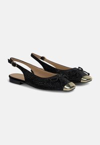 Schwarze Slingback-Flats mit einer strukturierten Oberseite, dekorativem Bogen und metallischer Schuhspitze. Enthält einen Riemen mit einer runden Schnalle.
