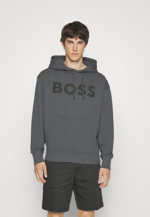 Sudadera gris de algodón con gran logo negro "BOSS", capucha con cordón y bolsillo tipo canguro, combinada con pantalones cortos negros con estampado.