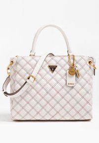 Weiße Stepphandtasche mit rot-schwarzem Karostich, doppelten Griffen, verstellbarem Schultergurt und goldfarbenen Guess-Logo-Anhängern.