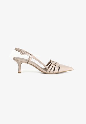 Tacón bajo tipo 'kitten heel' de piel beige con puntera puntiaguda y diseño de tiras recortadas en la parte superior del pie.