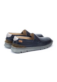 Zapatos de cuero de color navy tipo mocasín con punta redondeada, acento en ante beige y suela de goma gris, que cuentan con costuras en contraste a lo largo del borde.
