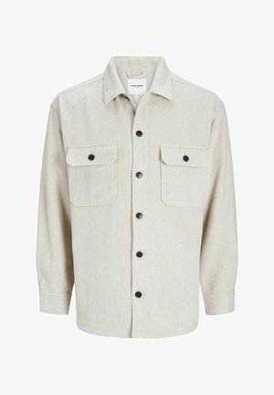 Beige flanellen overhemd met een kraaglijn, voorzien van twee borstzakken, zwarte knopen en lange mouwen met knoopmanchetten.